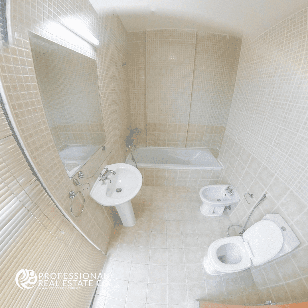 Spacious bathroom with shower and bathtub in semi-furnished 2 BHK apartment in Al Sadd, perfect for family living