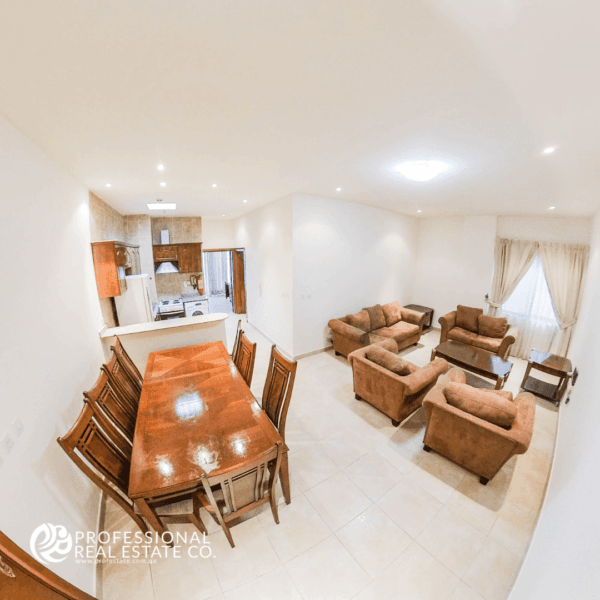 Another view of the spacious dining area, living room, and open kitchen in semi-furnished 2 BHK apartment in Al Sadd, ideal for family living