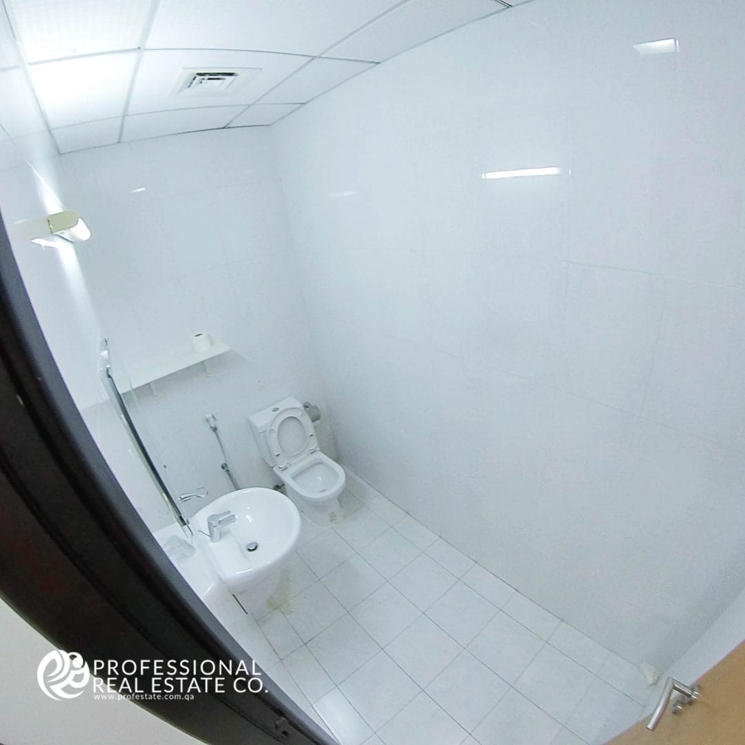 Inside view of the modern toilet area in an unfurnished office open space in Bin Mahmoud, providing essential amenities for business use