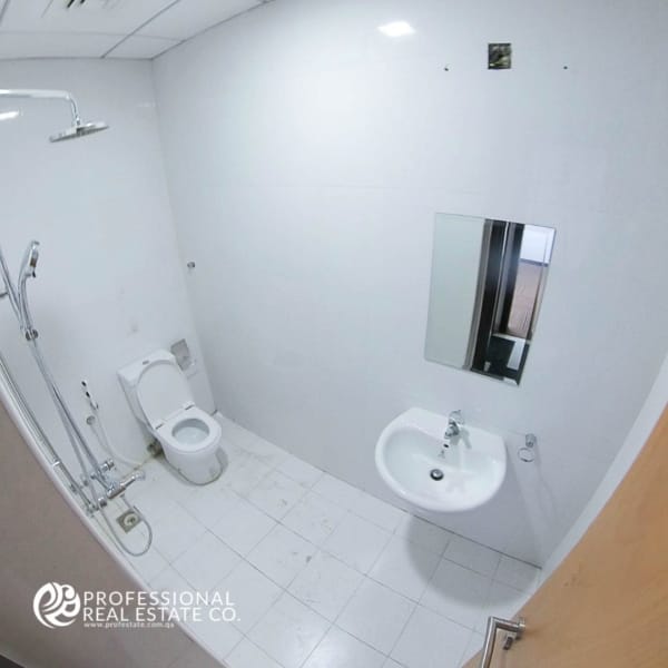 Modern toilet room with shower in an unfurnished office open space in Bin Mahmoud, ideal for business use