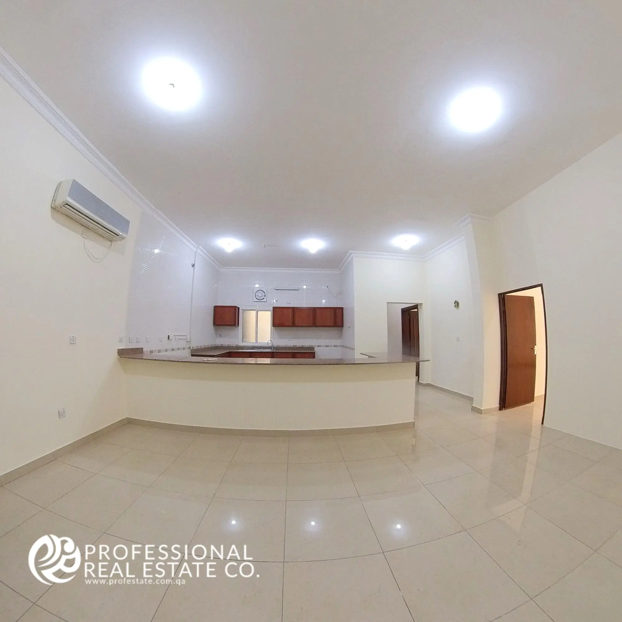 Spacious living room with a view of the open kitchen in an unfurnished 4 BHK apartment for rent in Al Naser, offering a bright, customizable living space.