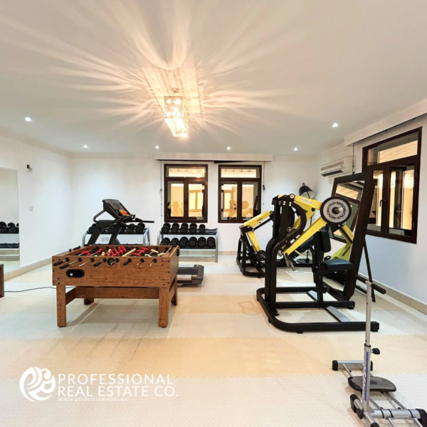 State-of-the-art gym in a fully furnished 5 BHK standalone villa in Umm Lekhba, featuring premium fitness equipment and a modern design for a luxury workout experience.