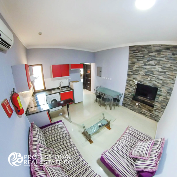 Alternate view of the stylish living room and dining area in a fully furnished 1 BHK apartment in Muaither, offering a cozy and functional space.