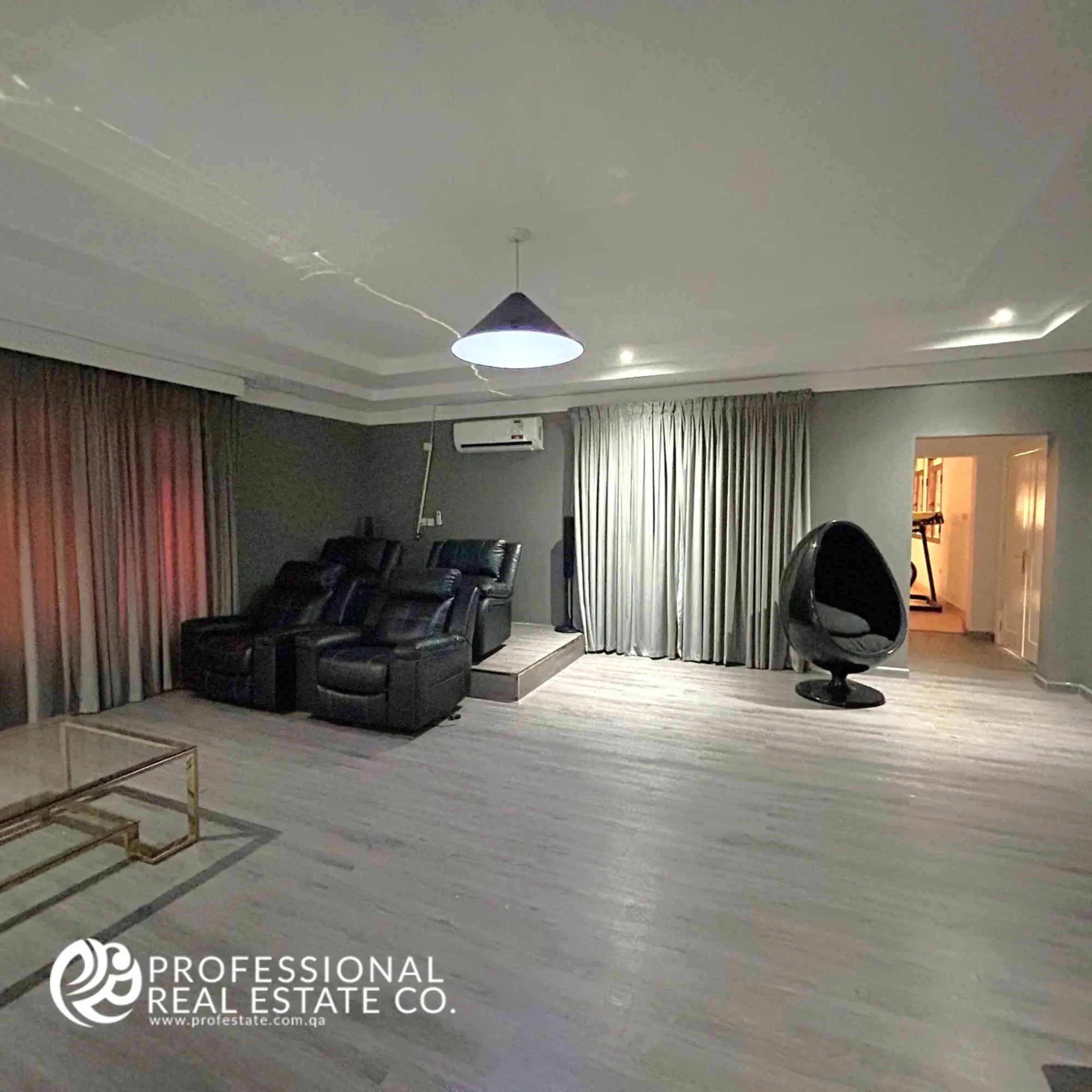 Entertainment room in a fully furnished, luxurious 5 BHK standalone villa in Umm Lekhba, featuring premium audiovisual equipment and modern, comfortable seating for ultimate relaxation.