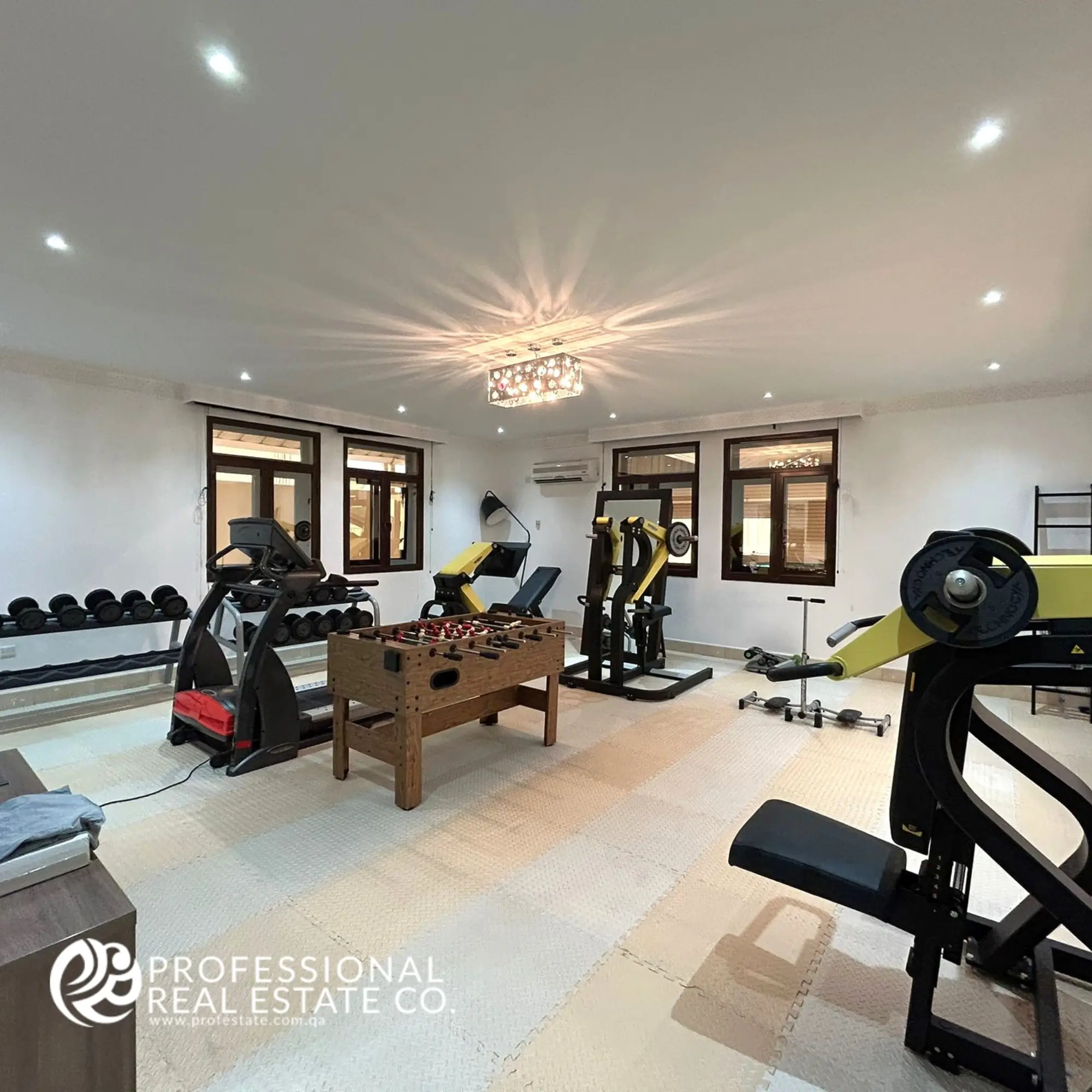 Alternative view of the fully equipped gym in a luxurious, fully furnished 5 BHK standalone villa in Umm Lekhba, showcasing high-end fitness equipment and modern design.