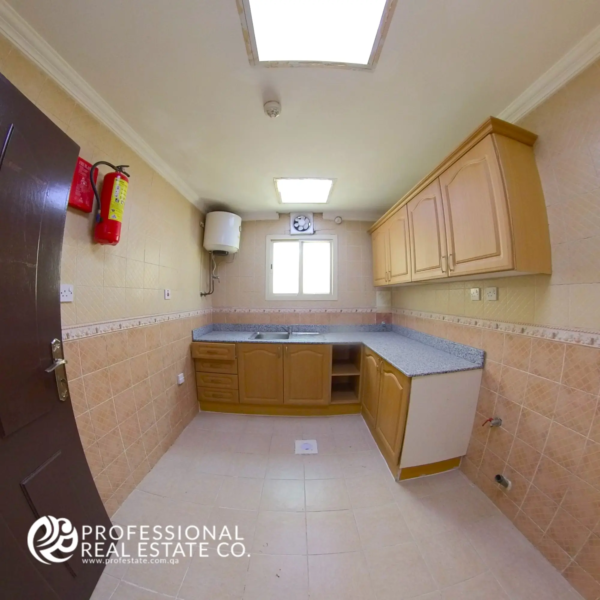 Closed kitchen with cabinetry and countertop in an unfurnished 2 BHK apartment in Al Sadd, Doha