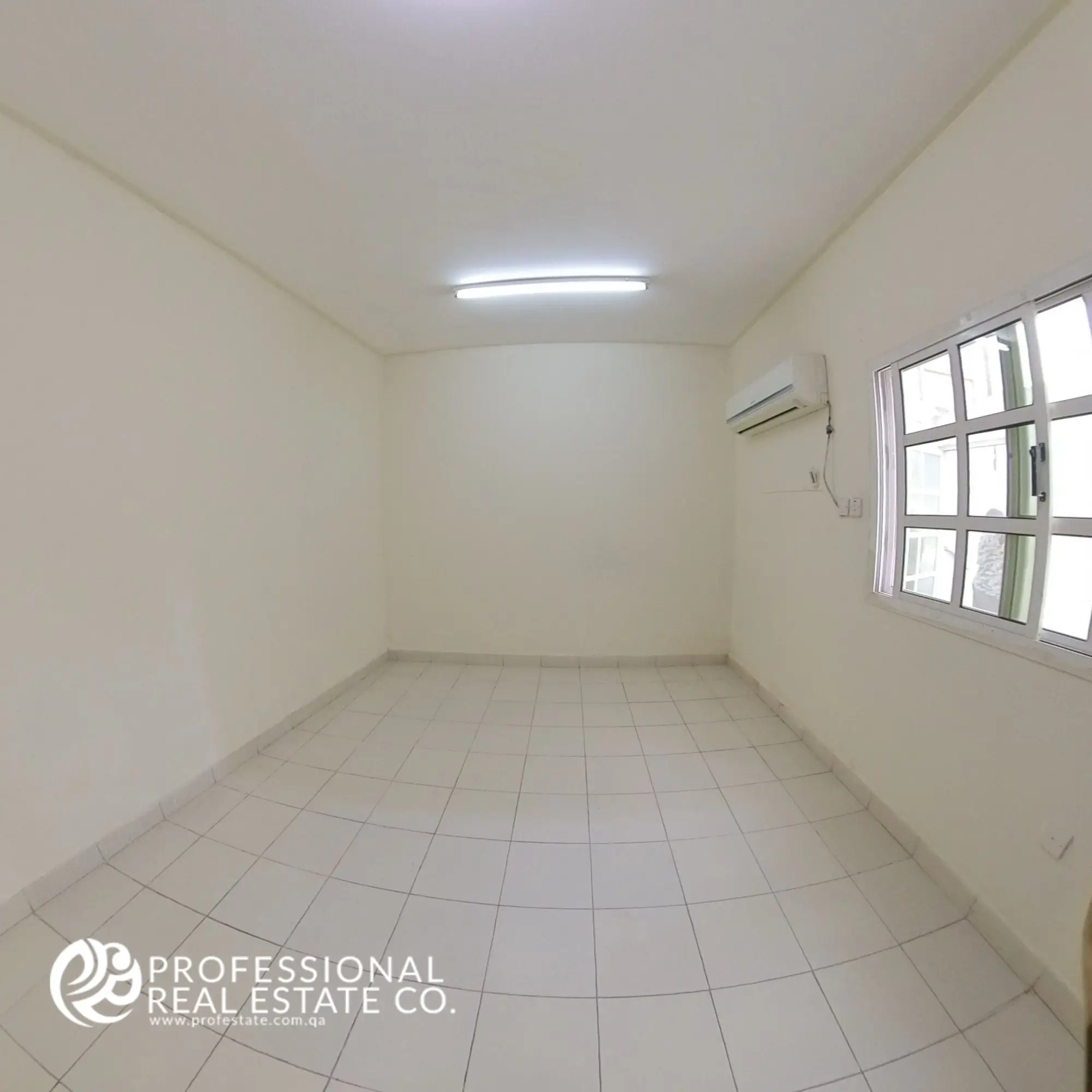 Spacious, unfurnished bedroom in a 1 BHK apartment for rent in Umm Lekhba, featuring ample natural light and a versatile layout ready for personalization.