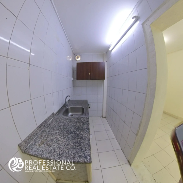 Modern open kitchen in an unfurnished 1 BHK apartment for rent in Umm Lekhba, featuring a spacious layout with ample counter space, perfect for creating your ideal cooking environment.