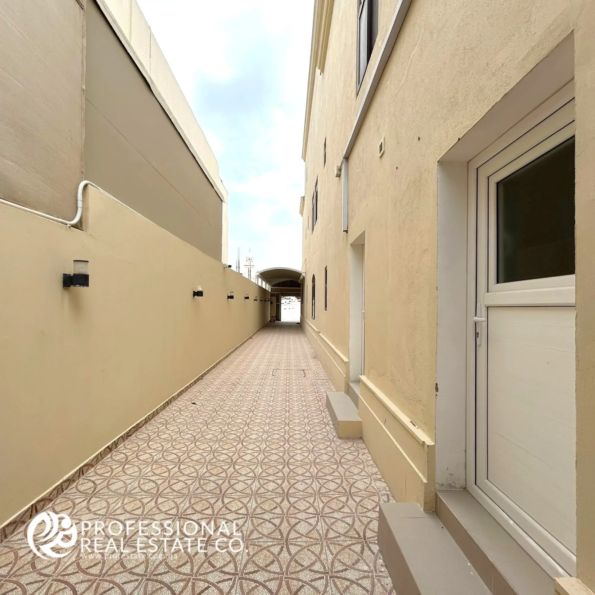 Charming external hallway with elegant finishes, offering seamless access to outdoor spaces in a fully furnished 5 BHK villa in Umm Lekhba.