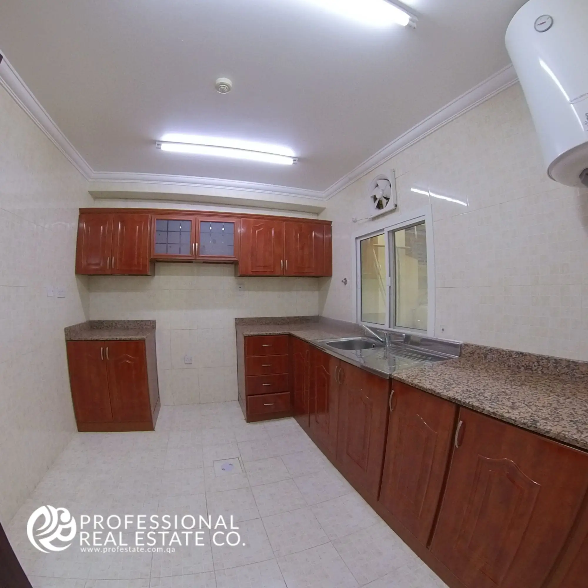 Closed kitchen in an unfurnished 2 BHK apartment in Al Gharrafa, offering a functional and private cooking space.