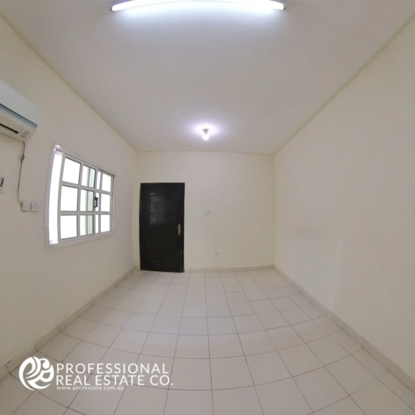 Another angle of the spacious, light-filled bedroom in an unfurnished 1 BHK apartment for rent in Umm Lekhba, showcasing its versatile layout and potential for personalization.