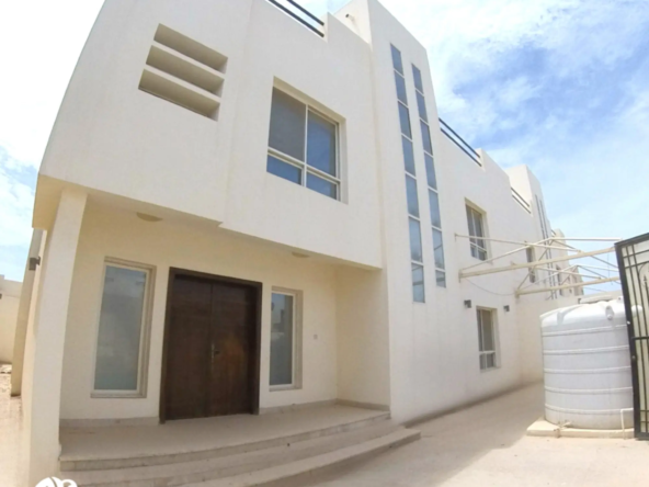 External view of the duplex building with 2 unfurnished 6 BHK villas in Al Ruwais, showcasing the structured façade, entryways, and gated surroundings.