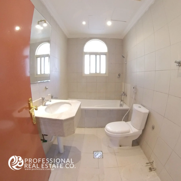 Modern bathroom with bathtub and clean tiling in a semi-furnished 2 BHK apartment for rent in Muntazah, Doha