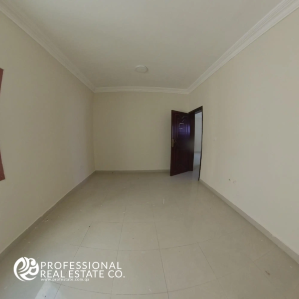 First bedroom with clean finishes and natural light in an unfurnished 2 BHK apartment in Muntazah, Doha