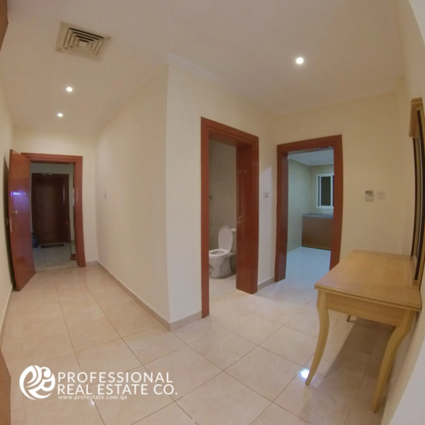 Main entrance and hallway leading to kitchen and toilet room in a semi-furnished 2 BHK apartment in Muntazah, Doha