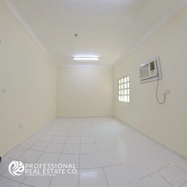 Standard bedroom with tiled flooring and window in 2 BHK unfurnished apartment in Najma, Doha