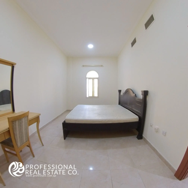 Spacious master bedroom with natural light and neutral finishes in a semi-furnished 2 BHK apartment in Muntazah, Doha