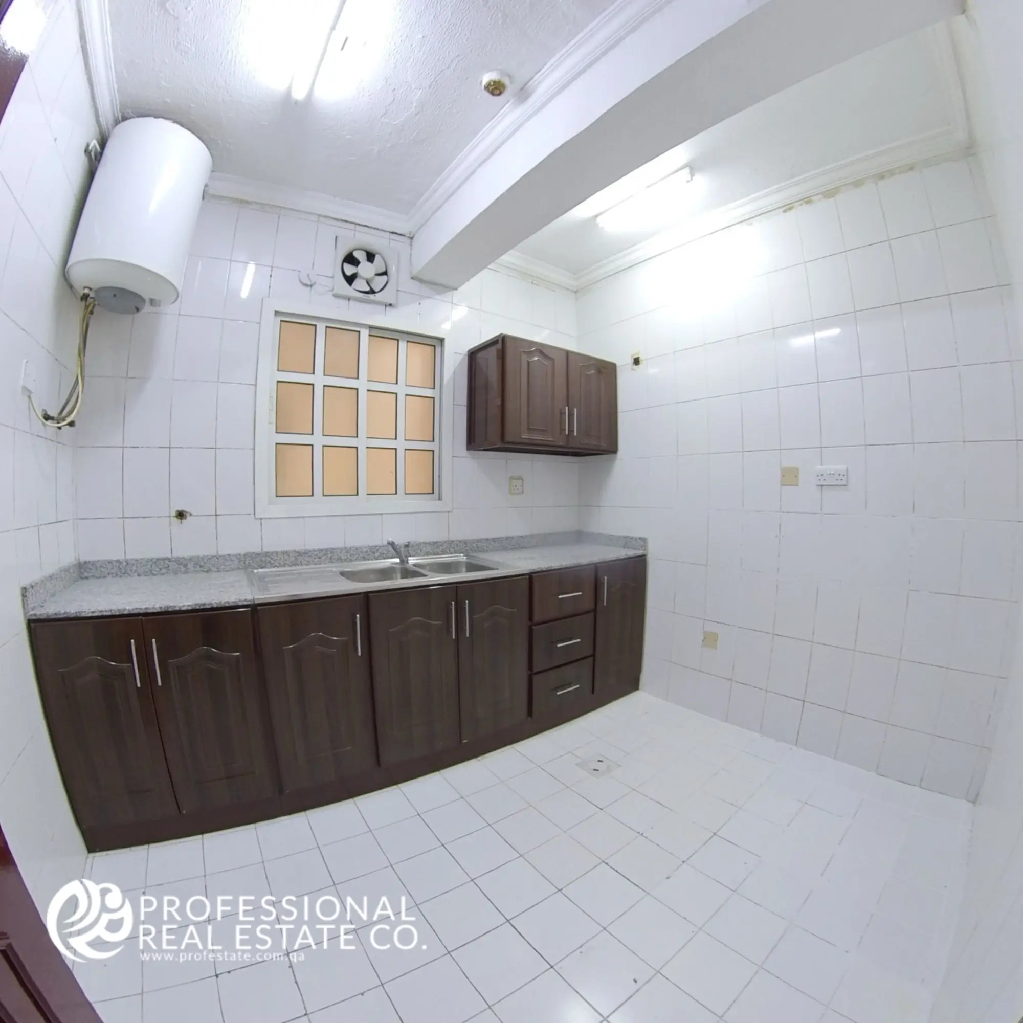 Alternative angle of closed kitchen with ample cabinet space in 2 BHK apartment in Najma, Doha