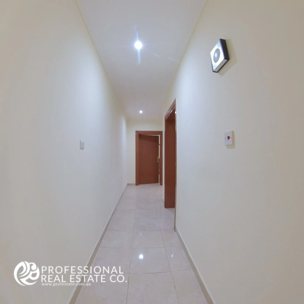 Well-lit hallway with tiled flooring in a semi-furnished 2 BHK apartment for rent in Muntazah, Doha