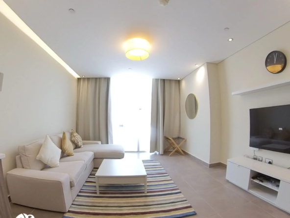 Alternative view showcasing the window side of the living room in a fully furnished 2 BHK apartment in Al Sadd, with abundant natural light and spacious design.