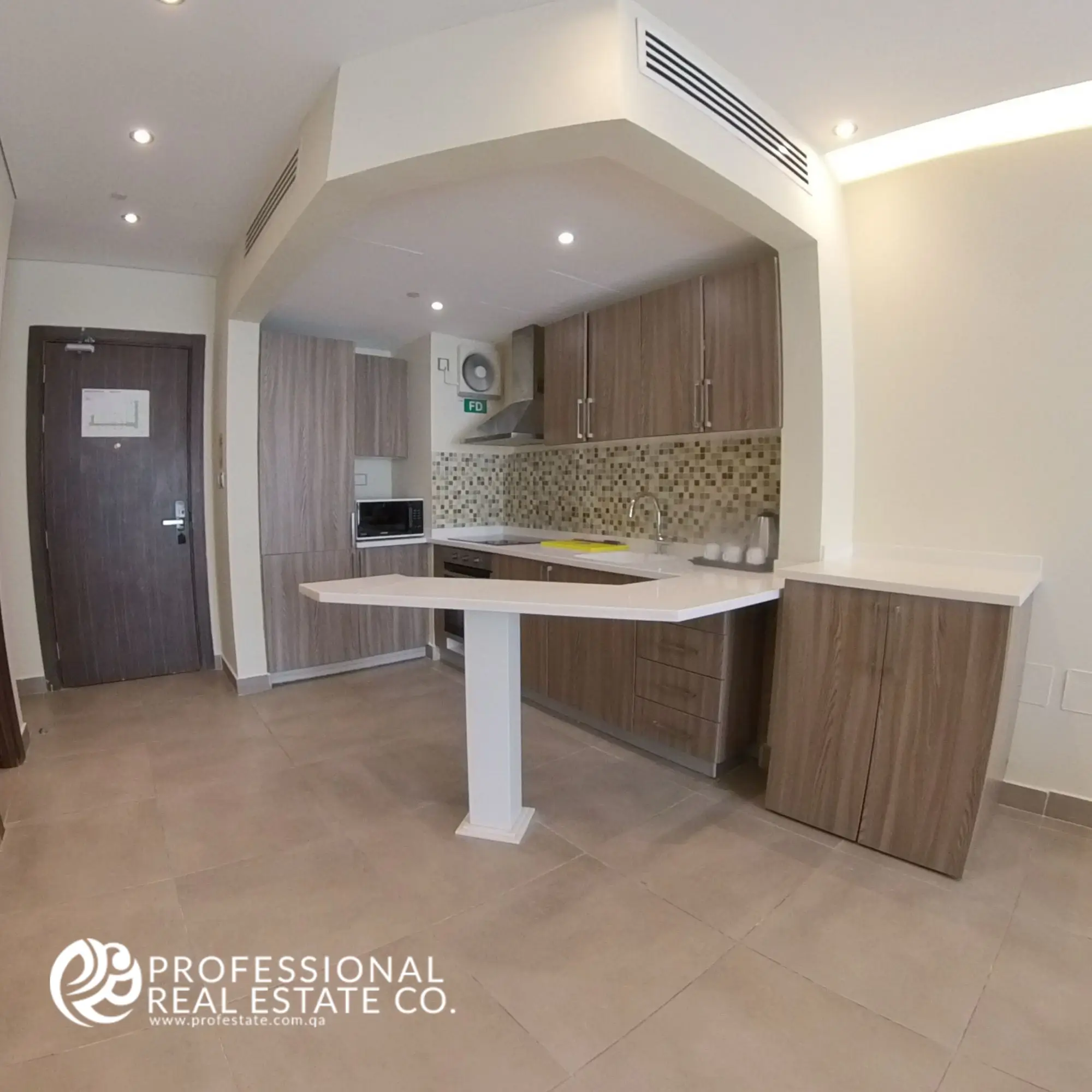 Open kitchen in a fully furnished 1 BHK apartment in Al Sadd, featuring modern appliances, sleek countertops, and a spacious layout.