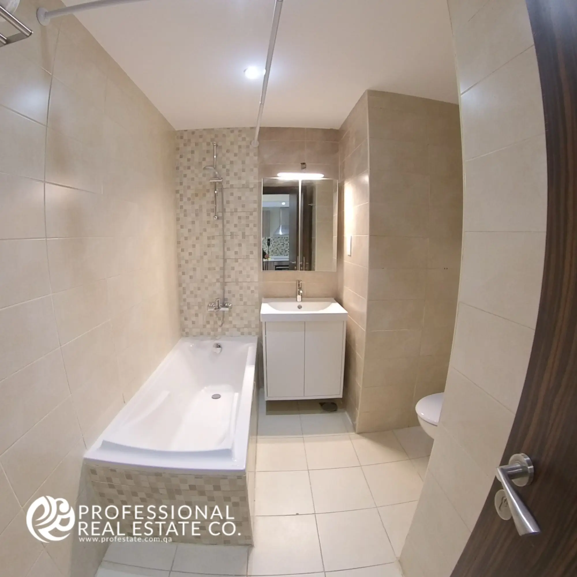 Toilet with bathtub and shower in a fully furnished 1 BHK apartment in Al Sadd, offering a relaxing and modern bathroom design.