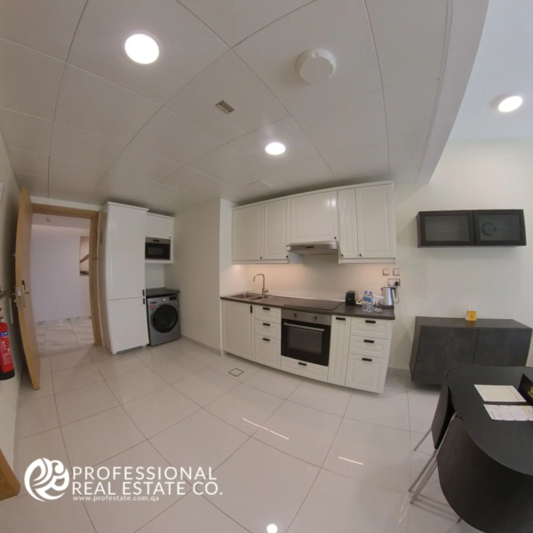 Alternative view of the open kitchen showcasing modern appliances and functional layout in a fully furnished 1 bedroom apartment in Bin Omran, Doha