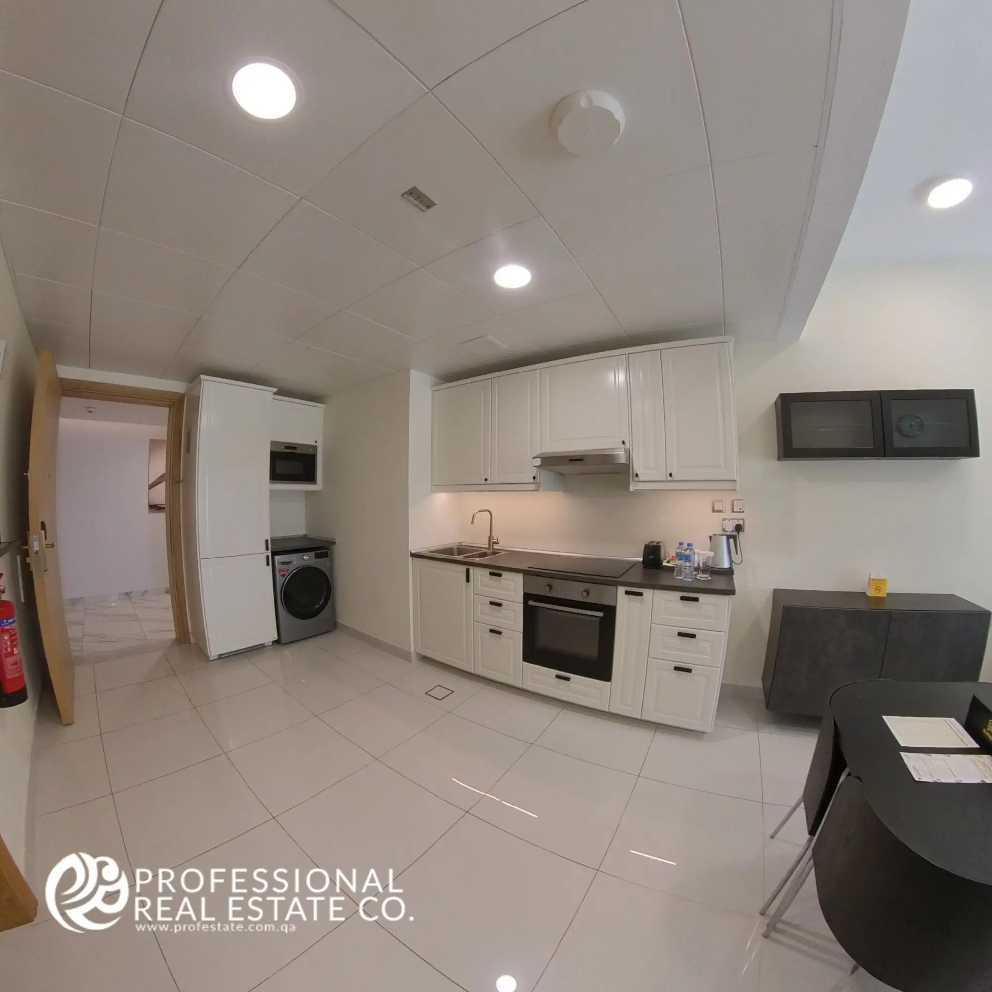 Alternative view of the open kitchen showcasing modern appliances and functional layout in a fully furnished 1 bedroom apartment in Bin Omran, Doha