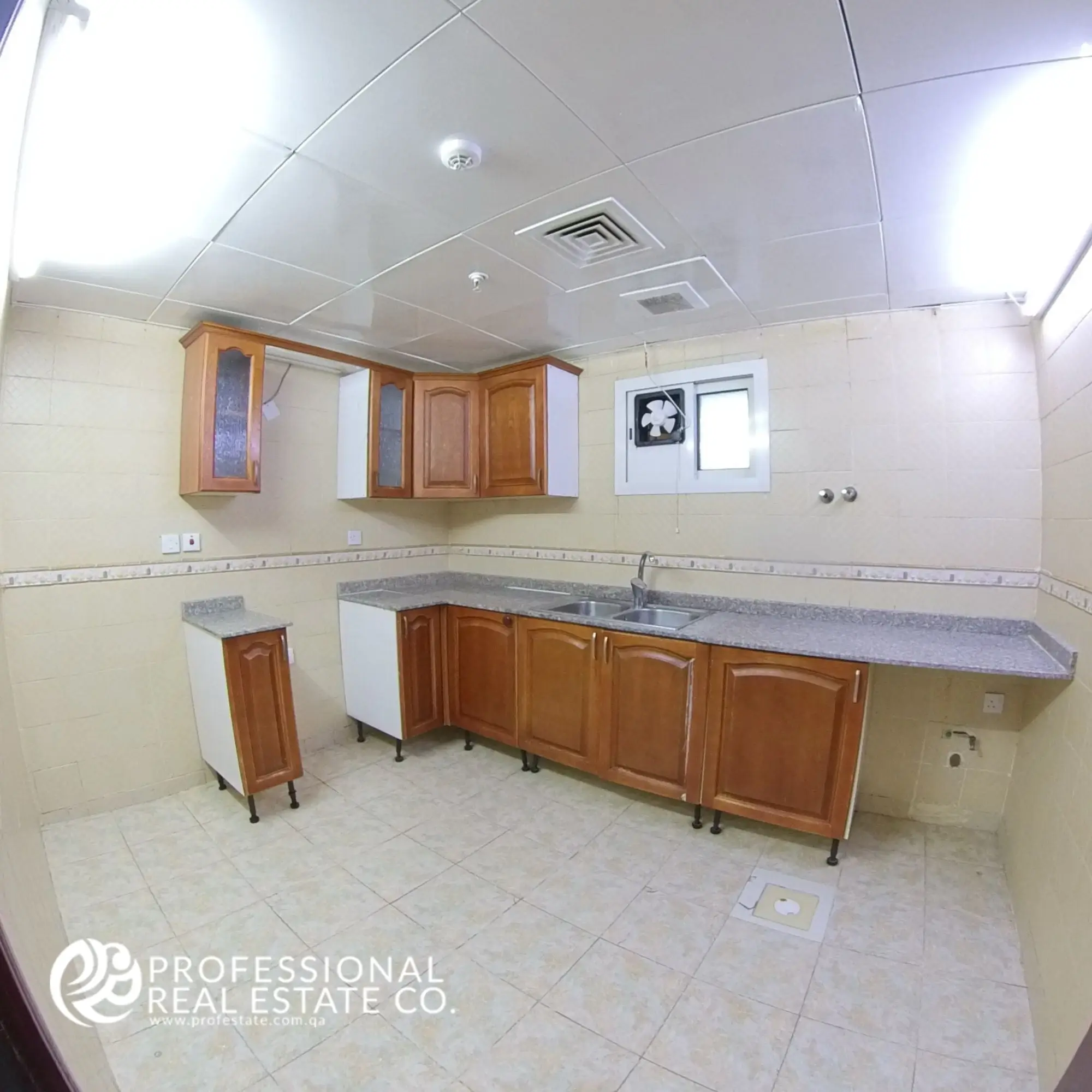 Closed kitchen with cabinetry and countertop in an unfurnished 3 BHK apartment in Bin Mahmoud, Doha
