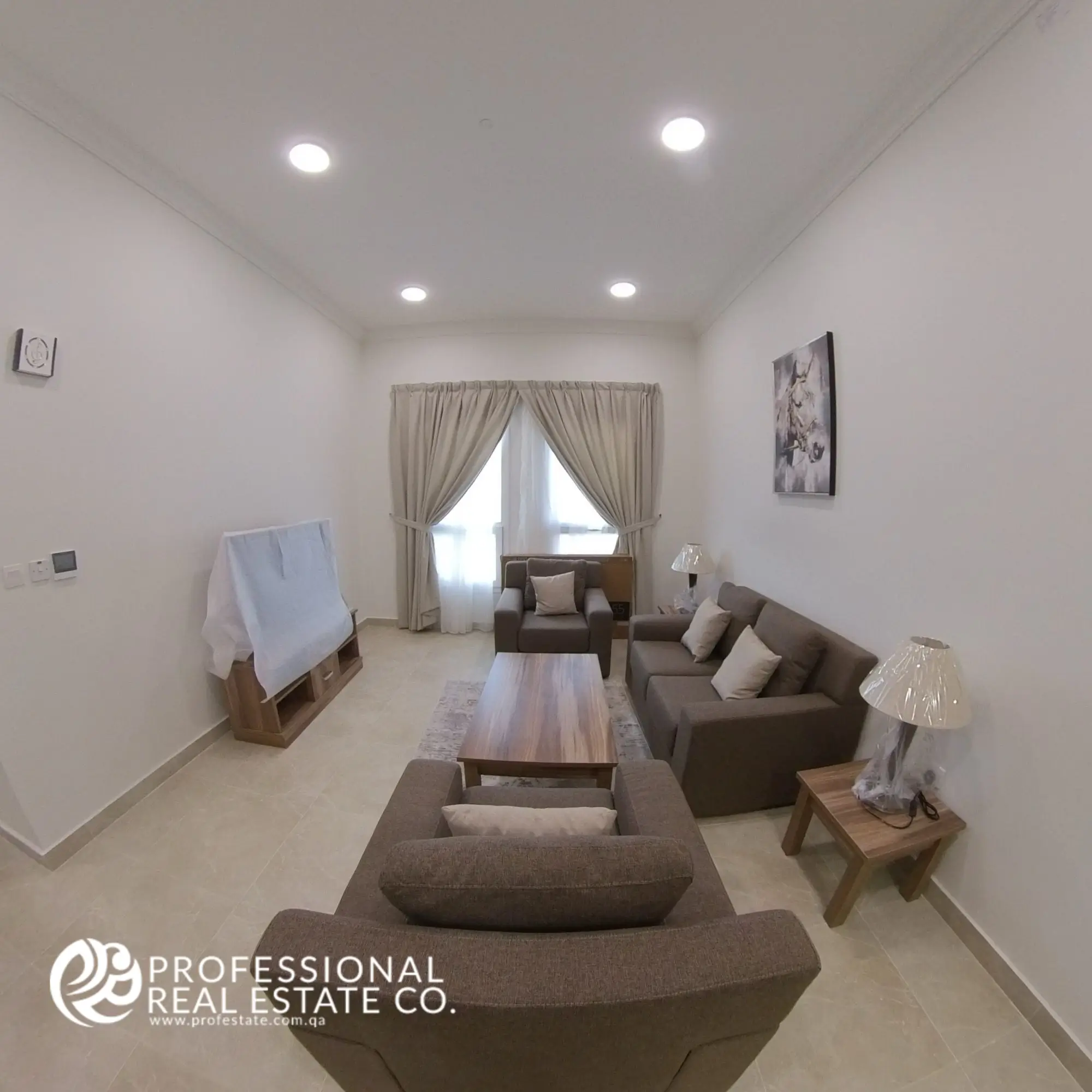Living room with modern furnishings and natural light in a fully furnished 2 BHK apartment in Al Waab, Doha