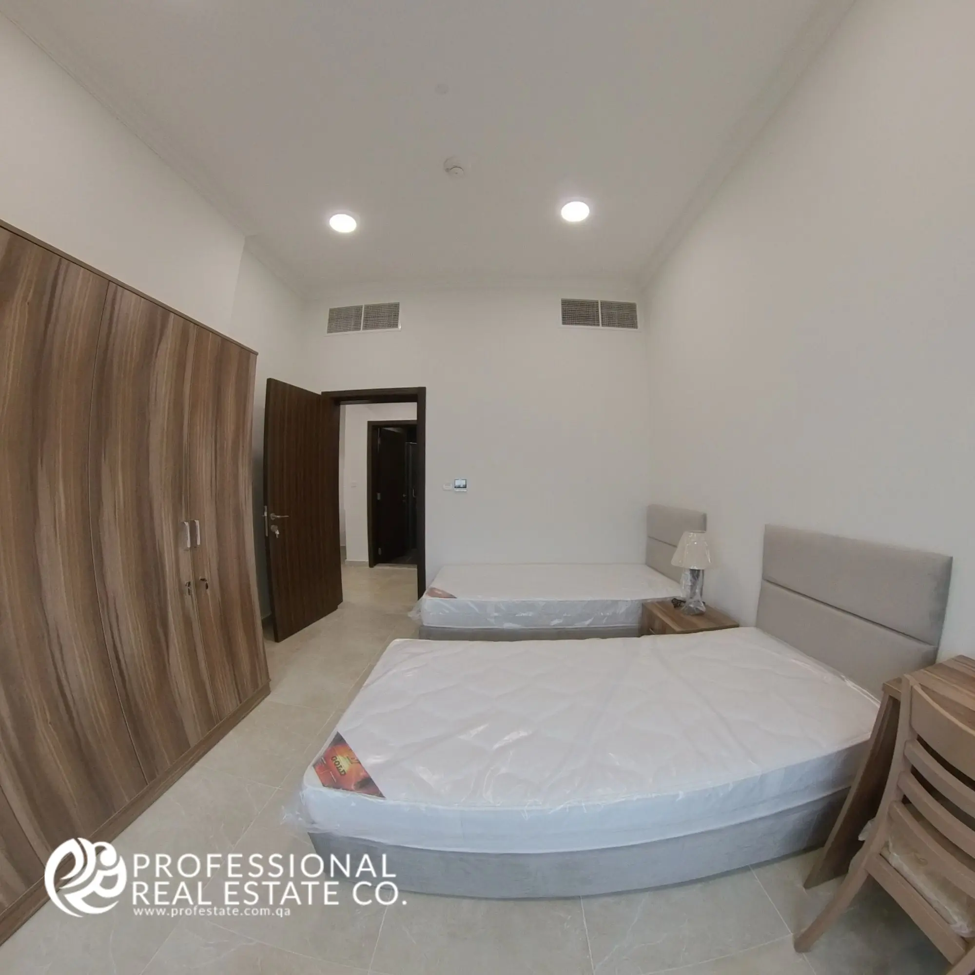Bedroom 2 with two single beds and modern furnishings in a fully furnished 2 BHK apartment in Al Waab, Doha