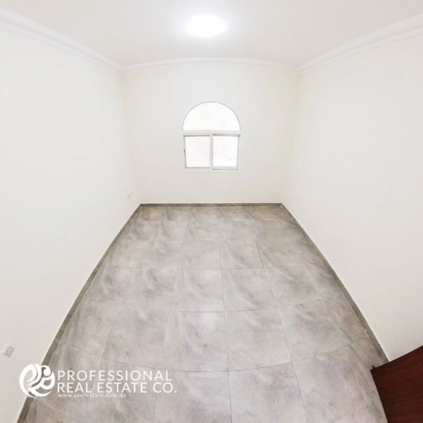Bedroom with tiled flooring and neutral walls in an unfurnished 1 BHK apartment in Muntazah, Doha