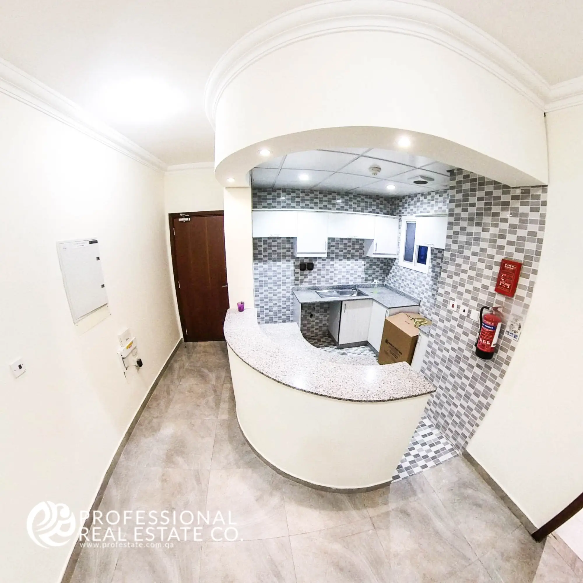 Open kitchen with tiled flooring and basic fittings in an unfurnished 1 BHK apartment in Muntazah, Doha