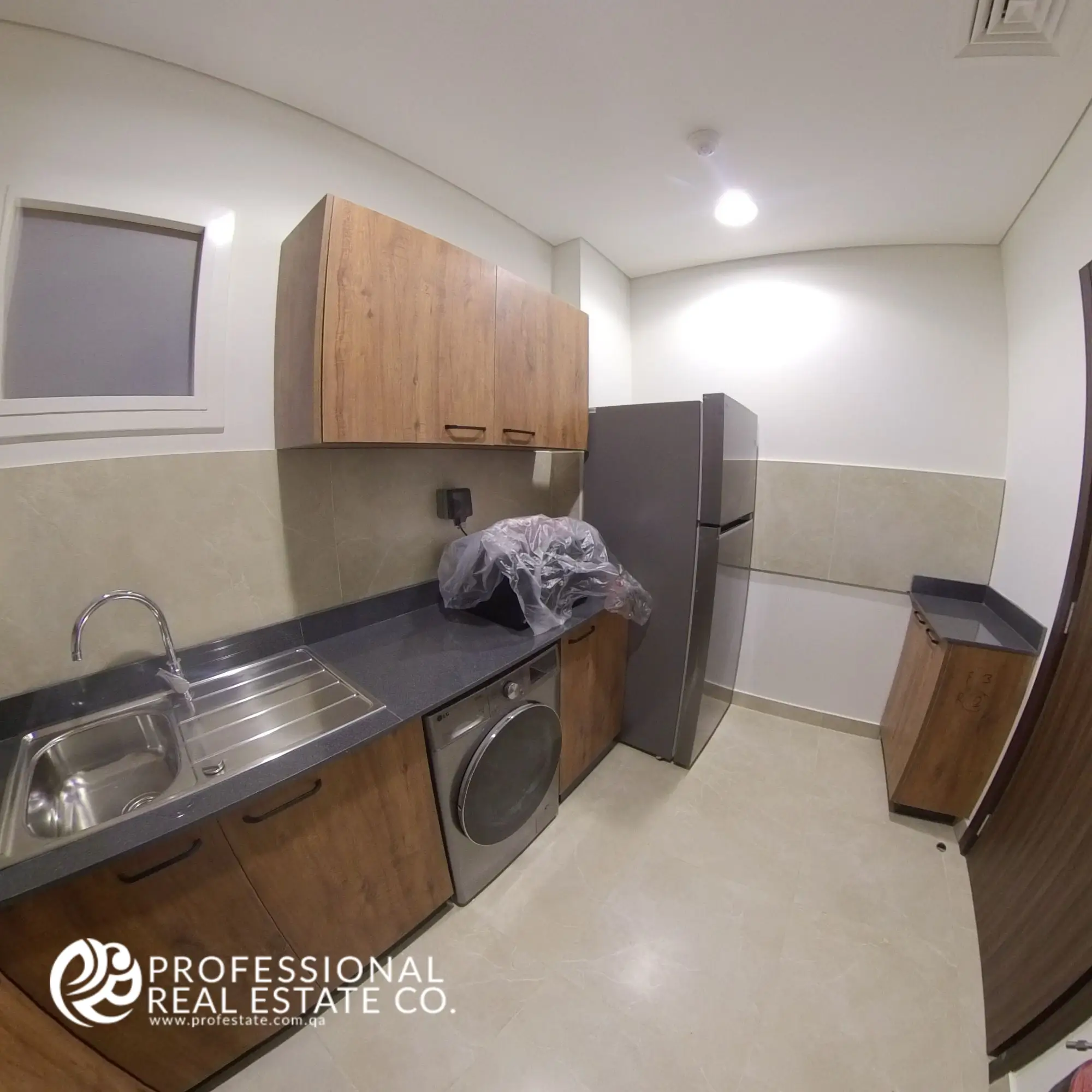 Closed kitchen with modern cabinetry and appliances in a fully furnished 2 BHK apartment in Al Waab, Doha