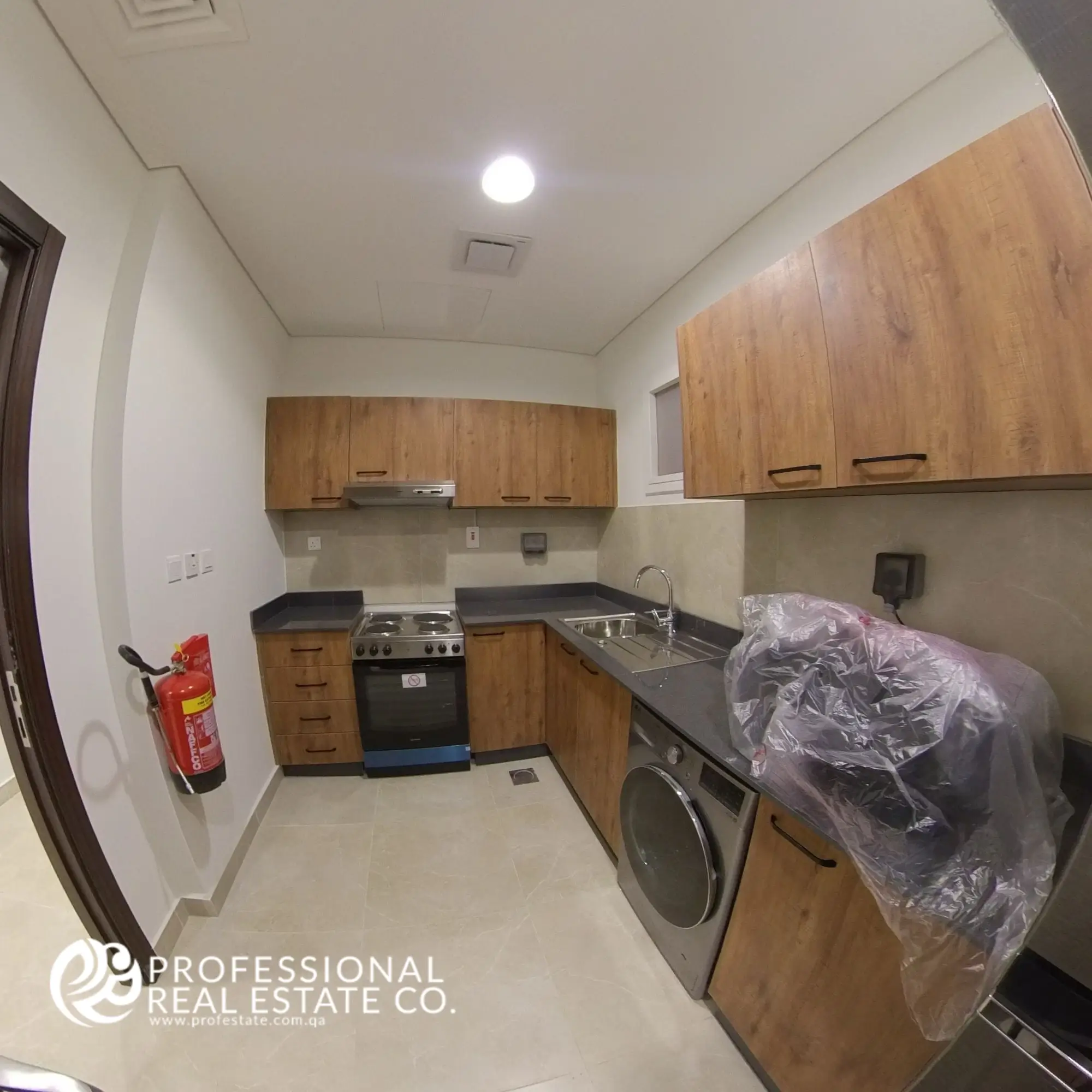 Alternative view of closed kitchen with modern cabinetry and appliances in a fully furnished 2 BHK apartment in Al Waab, Doha